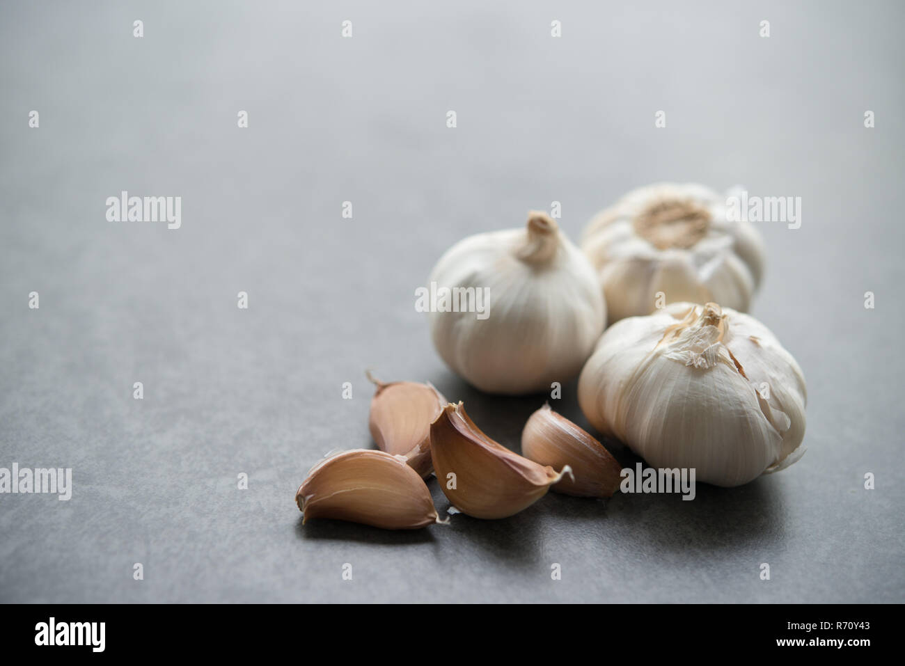 Garlic cloves and bulb with copy space on dark background Stock Photo ...