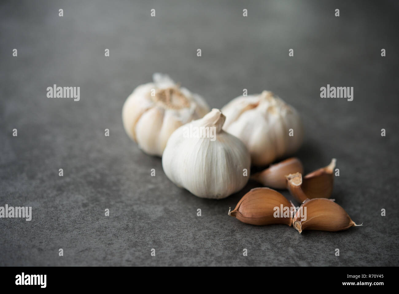 Garlic cloves and bulb with copy space on dark background Stock Photo ...