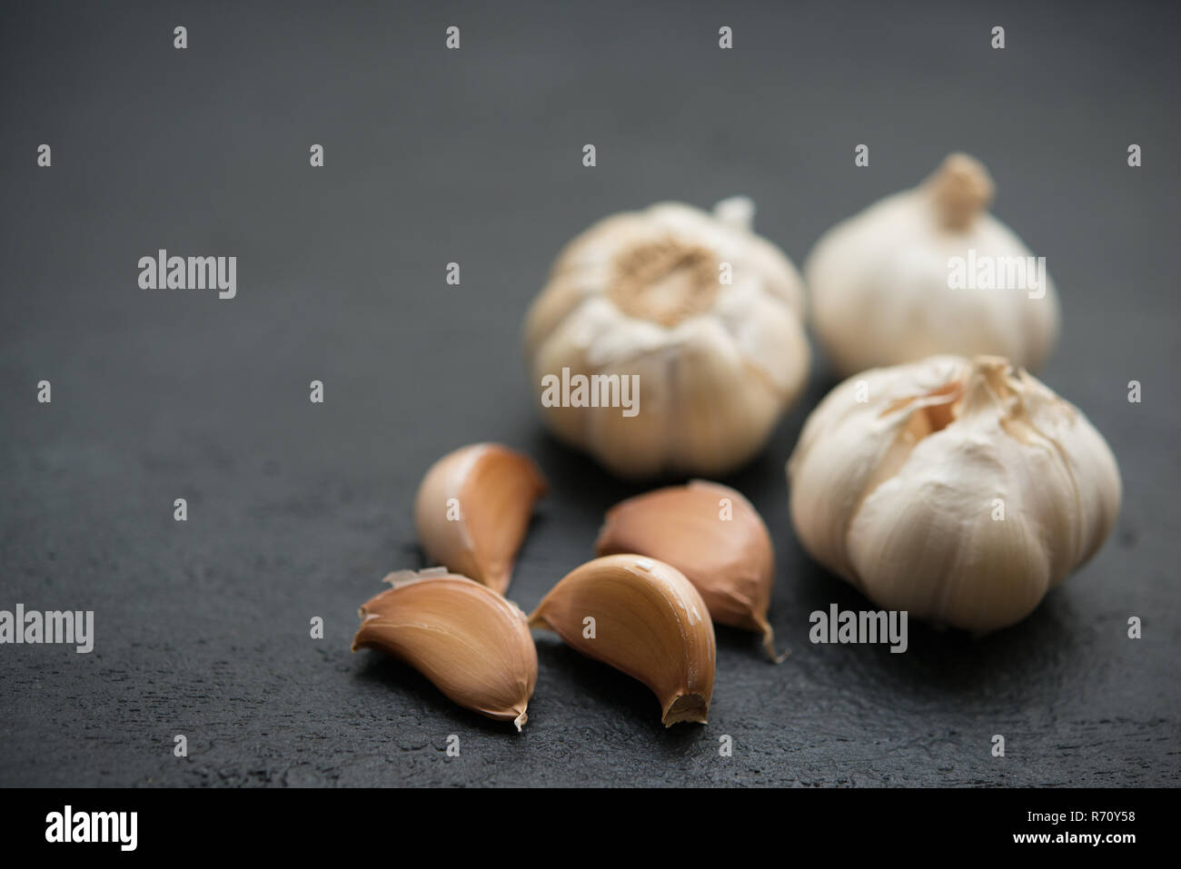 Garlic cloves and bulb with copy space on dark background Stock Photo ...