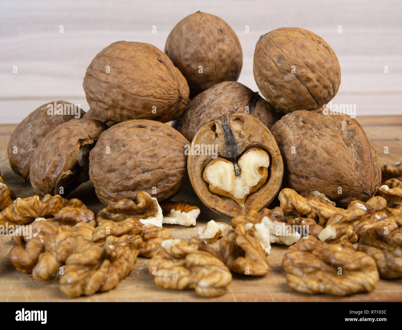 A splited heart-shaped wallnut and a pile of wallnuts Stock Photo - Alamy