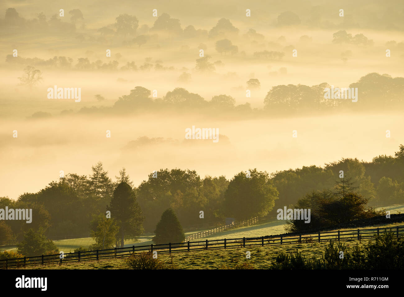 Long-distance, foggy, early morning view over scenic rural Wharfedale, the valley shrouded in mist or fog - near Ilkley, West Yorkshire, England, UK. Stock Photo