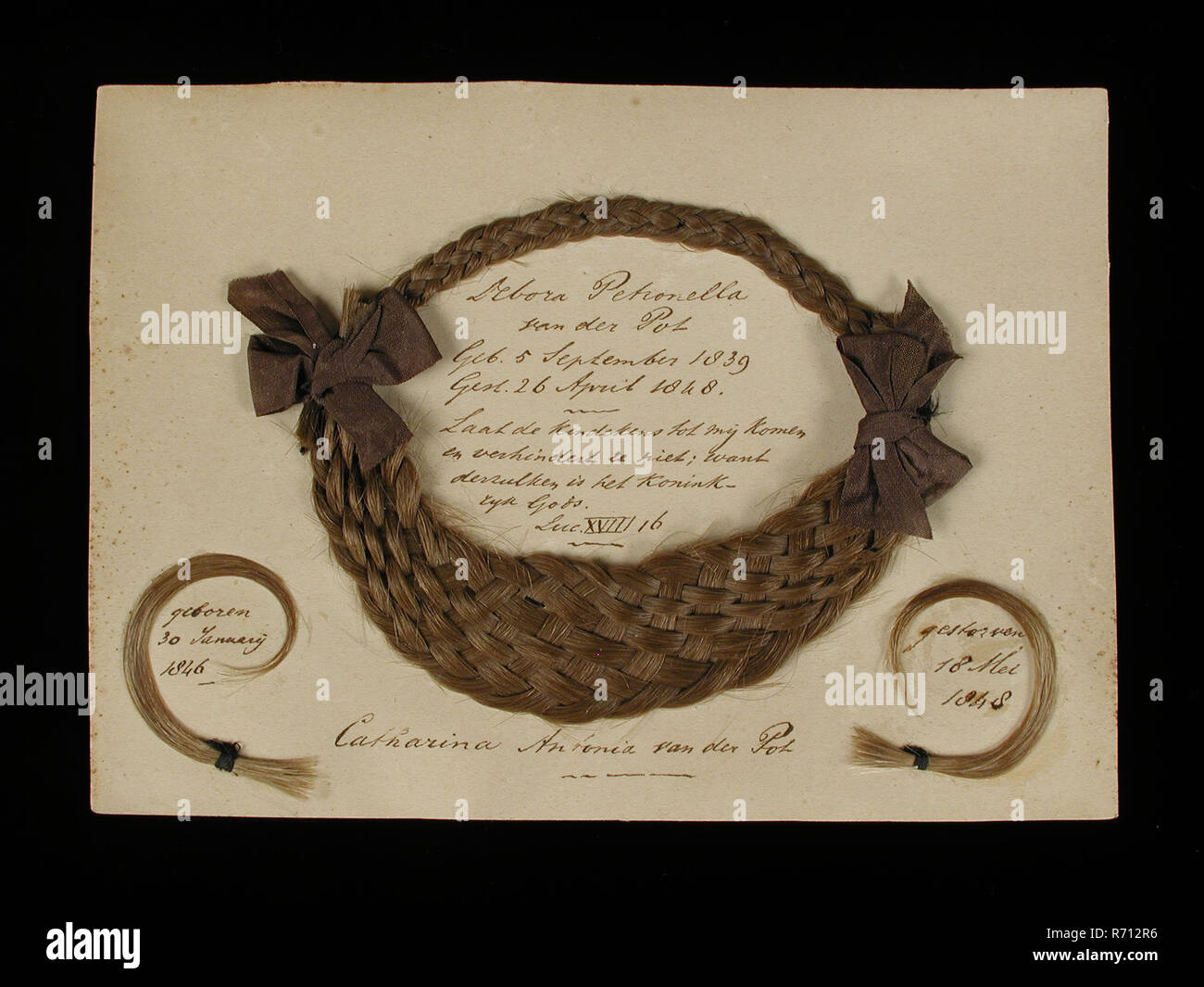 Oval braided hair wreath with inscription, Debora Petronella van der Pot 1848 and Catharina Antonia van der Pot 1848, on the map, hair work her paper ink, Hair piece on white card the size of an envelope an oval braided hair ring that is widest from the bottom and left and right is held by dark bow in it text text inside the envelope hair wreath: Debora Petronella van der Pot Geb. 5 September 1839 Gest. April 26, 1848 Let the little children come to me and do not prevent; for such is the Kingdom of God Lac XVIII 16 left at the bottom of her curl: born January 30, 1846 remembrance memorial deat Stock Photo