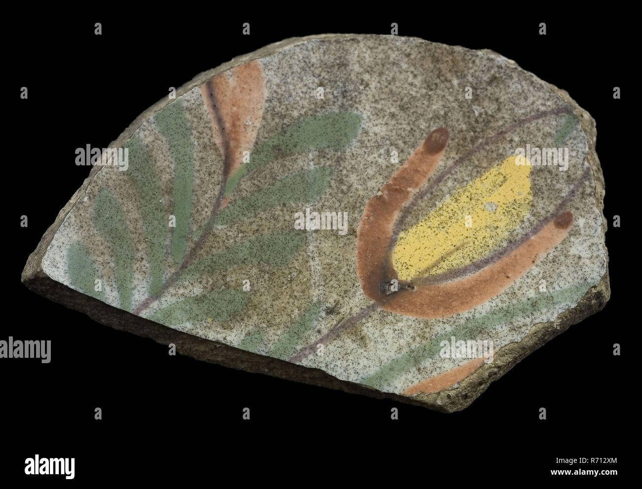 Soil fragment faience plate with polychrome flower on white ground, plate dish crockery holder soil find ceramic earthenware glaze tin glaze, hand turned baked decorated glazed baked Soil fragment faience plate on stand surface Fully glazed brown discolored by staying in the soil Yellow shard. Polychrome flower in the mirror tulip in yellow red purple and green archeology Schiedam native pottery serve serving food table archaeological find in the soil weedstraat Schiedam 1973. Stock Photo