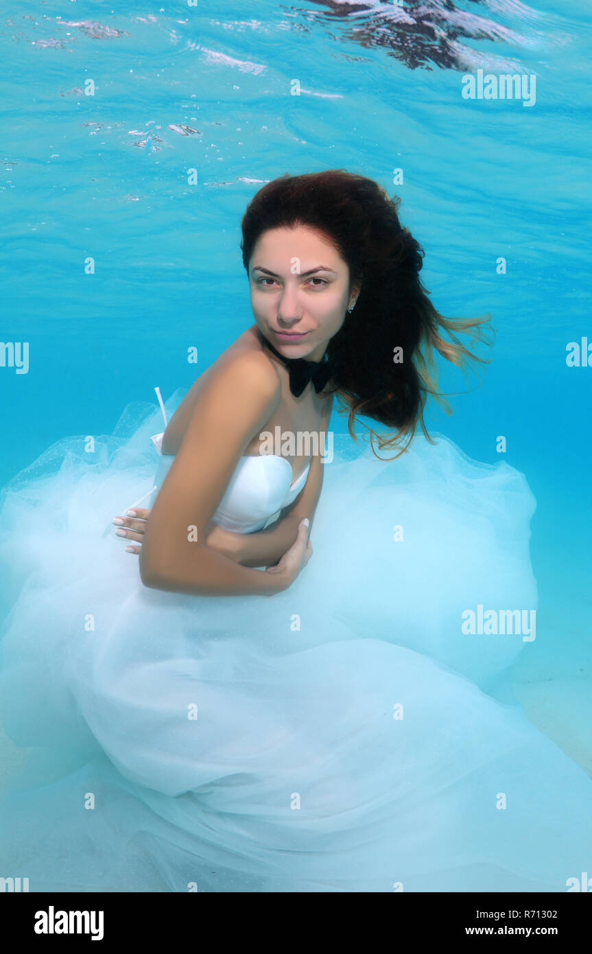 Young beautiful woman in a wedding dress underwater, Indian Ocean, Maldives Stock Photo
