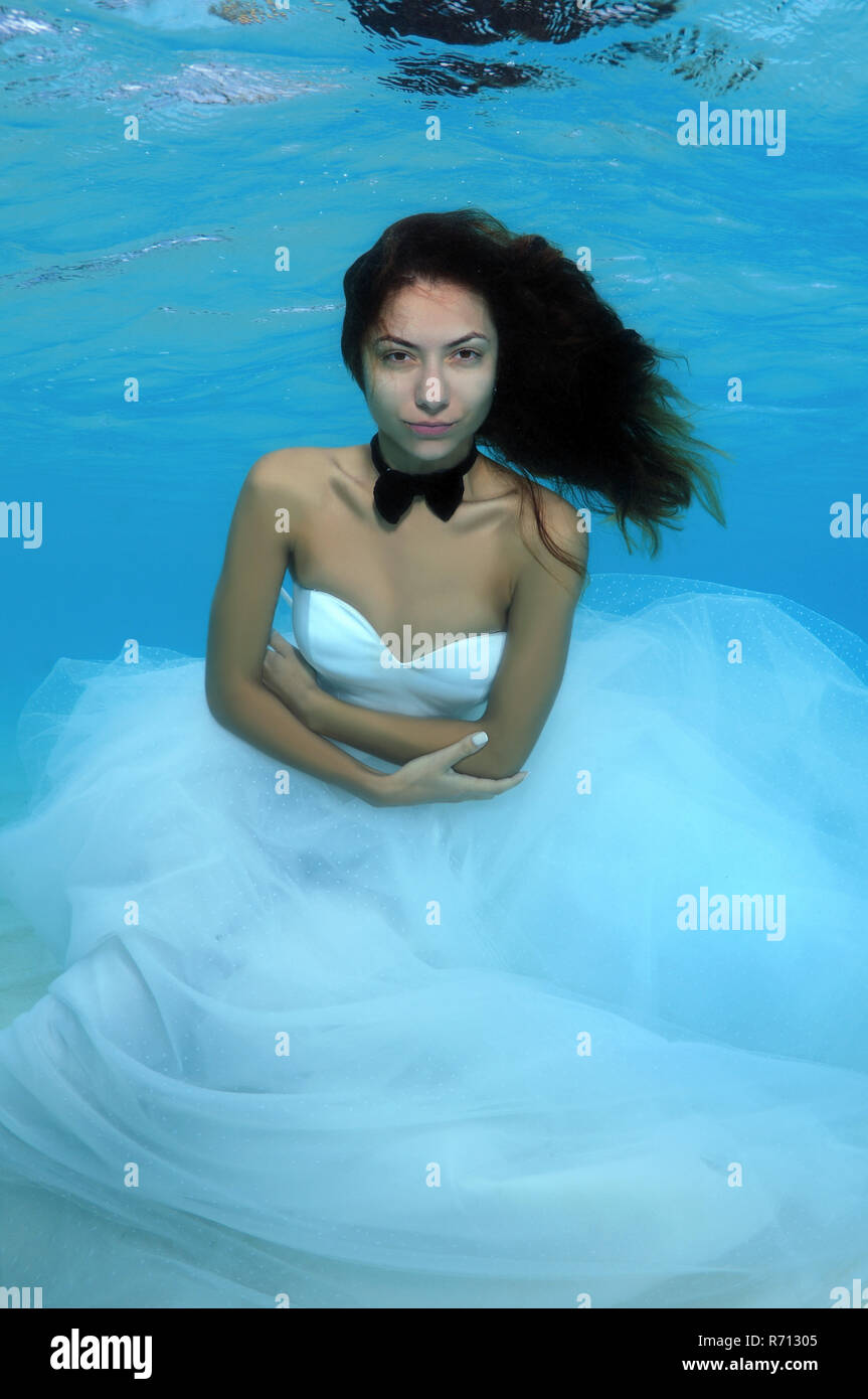 Young beautiful woman in a wedding dress underwater, Indian Ocean, Maldives Stock Photo