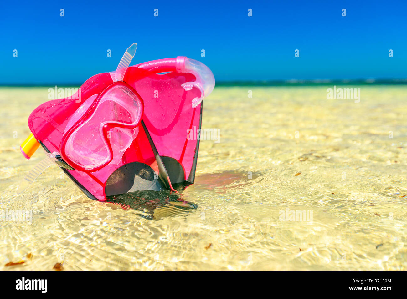 Summer equipment for snorkeling. Close-up of scuba mask with fins in pink color on the sand. Hangover Bay in Nambung National Park, Western Australia. Blue sky with copy space. Stock Photo