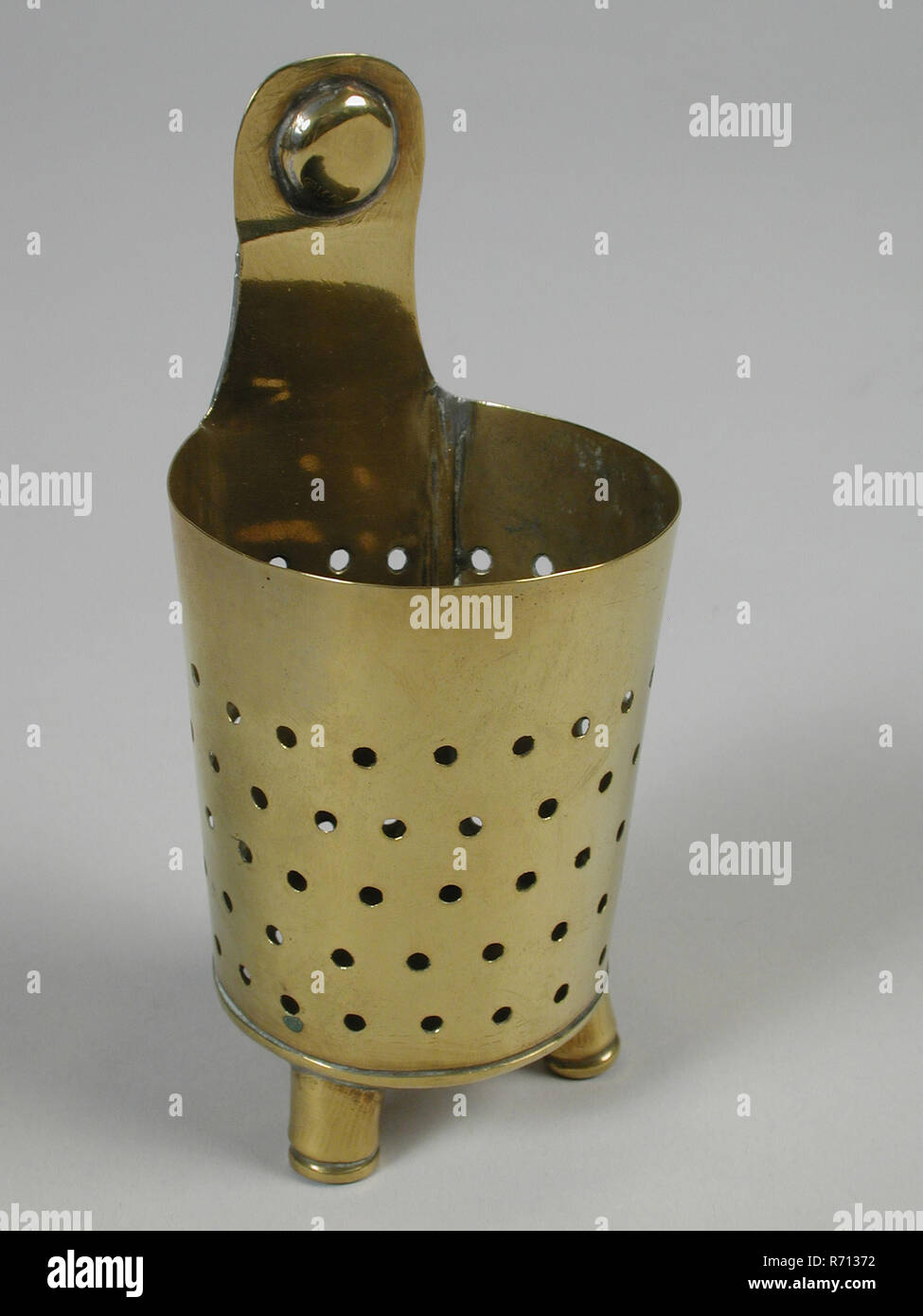 https://c8.alamy.com/comp/R71372/metal-worker-gresnich-yellow-copper-tea-leaves-colander-colander-sieve-kitchen-utensils-equipment-miniature-toy-relaxant-model-brass-filed-soldered-front-weakly-conical-and-perforated-backside-flat-and-merging-into-hanging-clip-three-legs-1868-sibilla-van-embden-playing-seven-kitchens-R71372.jpg