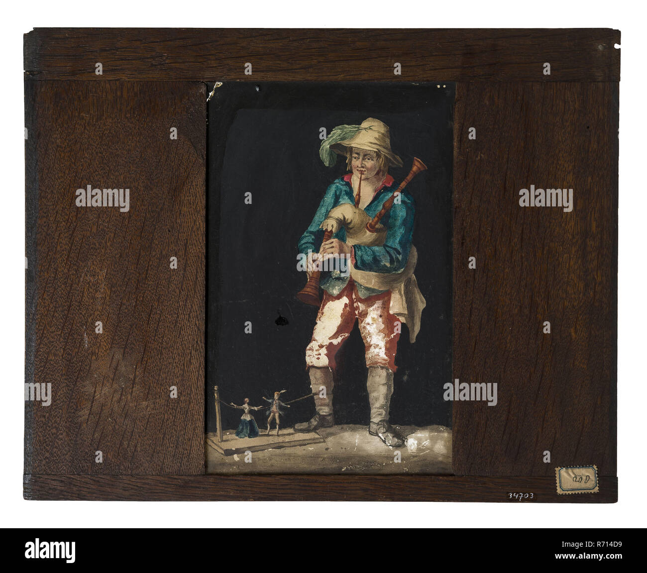 Hand-painted glass plate in wooden frame for illumination cabinet, image bagpipe player with dancing dolls, slideshelf slideshoot images glass paint wood oak leg, dimensions) handpainted Hand-painted glass for illumination cabinet in wide oak frame The frame is rejuvenated on the sides and shows wear and discolouration: the plates were pushed into an illumination cabinet from above. At the back left and right above two small legs fastening points for the illumination cabinet. Image of bagpipe player with his right leg making two puppets dance on string optics folk life Stock Photo