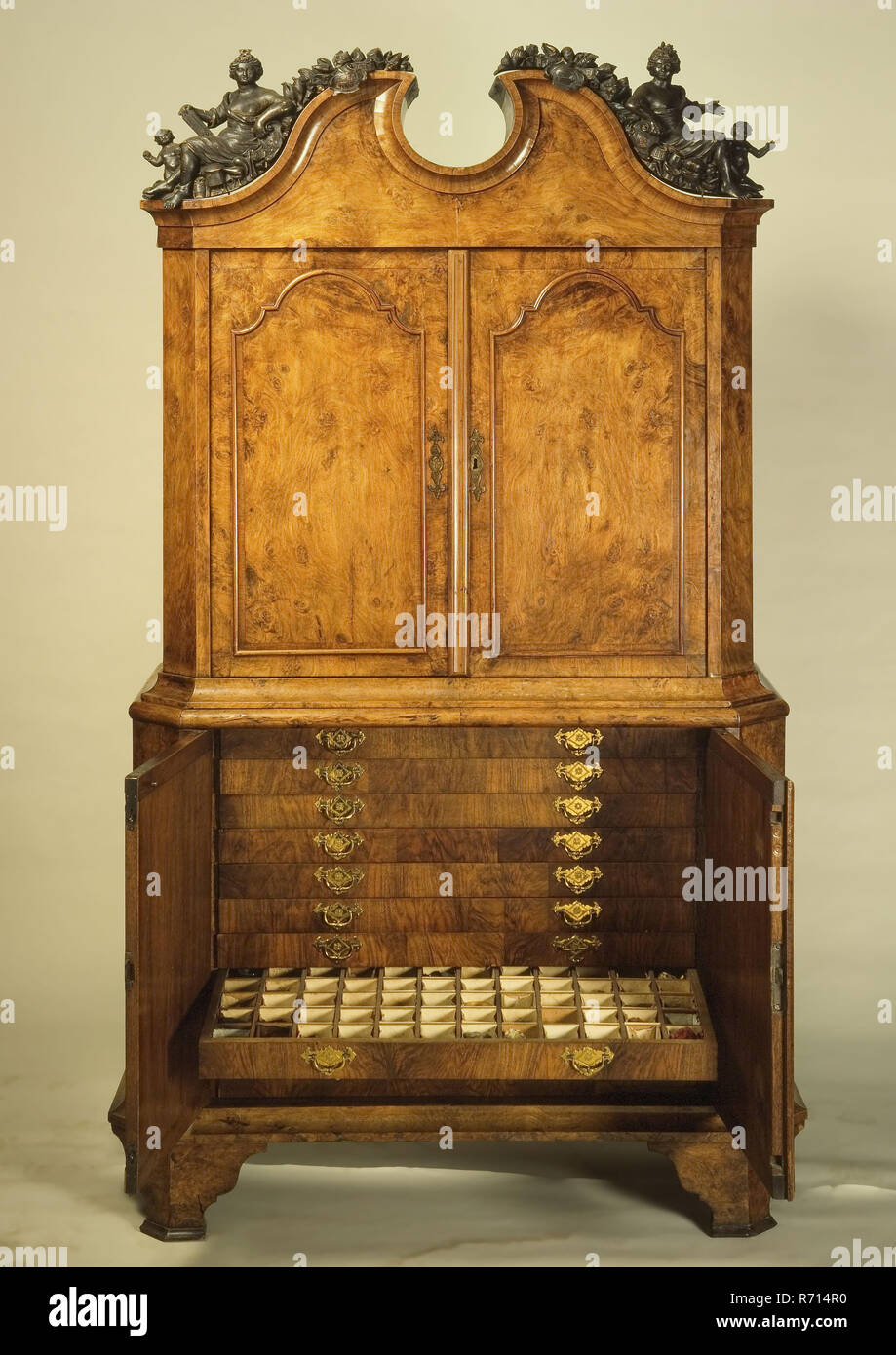 Simplicity cabinet Rotterdam surgeon's guild, with two separate figures on the hood: Hygiaea and Flora, simplicity cabinet furniture furniture interior interior design wood oak wood walnut burr walnut bronze, approx 150 kg Simplicity cabinet Rotterdam surgeon's guild four-door cabinet consisting of top and bottom cabinet in bottom drawers containing raw materials simplicia for medicines . Oak core veneered with walnut and burr walnut On the hood two removable female figures Hygiaea (Goddess of health) and Flora (goddess of flowers and spring) In the middle stood until the beginning of the 20th Stock Photo