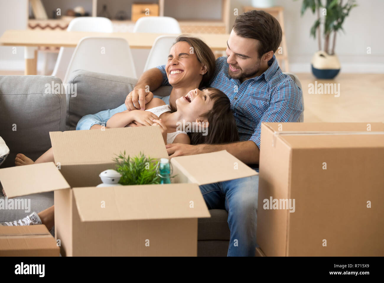 Laughing family spend time having fun at new home  Stock Photo