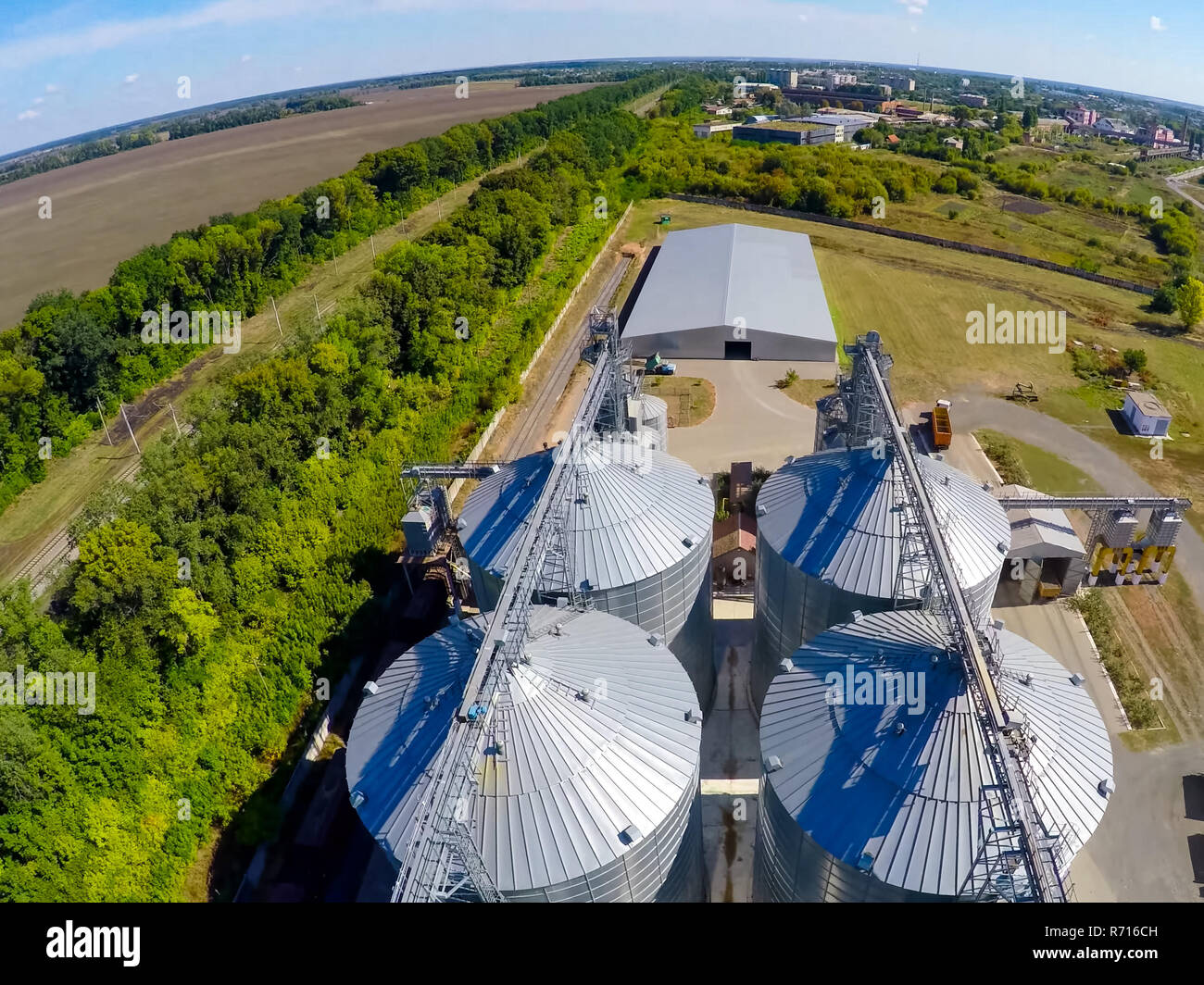 Flight of the grain terminal from the drone. The grain plant for storage and drying of grain. Grain terminal. Plant for the drying and storage Rice plant in the middle of fields Stock Photo