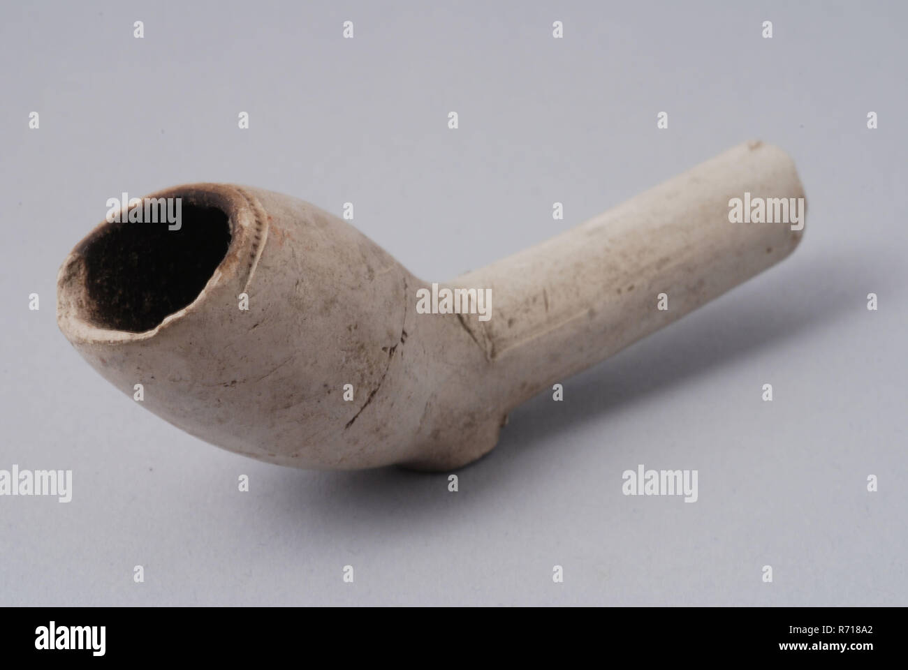 White clay pipe, unnoticed, with smooth handle, clay pipe smoking equipment smoke floor earthenware ceramic pottery, pressed finished baked White clay pipe unnoticed with smooth handle Pipe has smooth transition from the front of the kettle to the handle with the heel the break of that line is Hole in the bottom steel archeology smoking tobacco Stock Photo