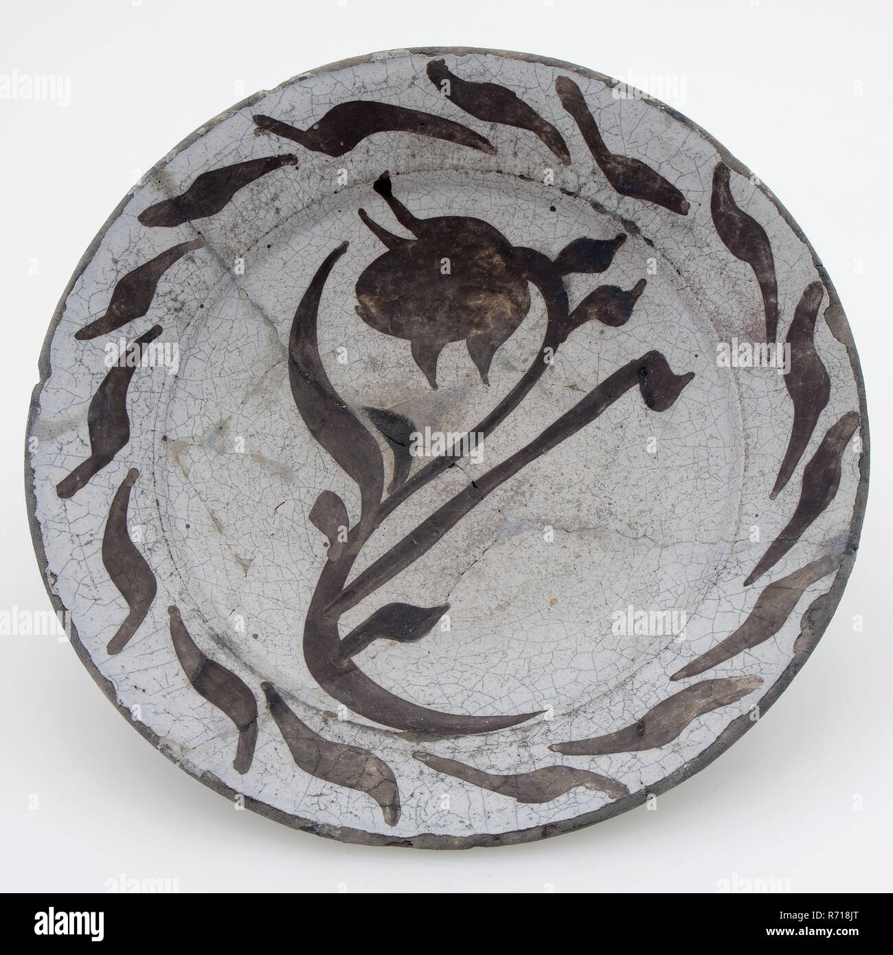 Pottery plate, decorated with plant in purple on white ground, plate dish crockery holder soil find ceramic earthenware glaze tin glaze, hand turned glazed baked Pottery plate decorated with stylized plant in purple on white fond. Decoration consists of flowering plant in the middle of the plate. Around it wreath of leaves on the edge. Plate is fully glazed. Stand with light soul archeology Rotterdam Overschie Kleinpolder Polderkade indigenous pottery served table food room table Ground discovery: Overschie 1979 De Lugt at the Polderkade. Stock Photo
