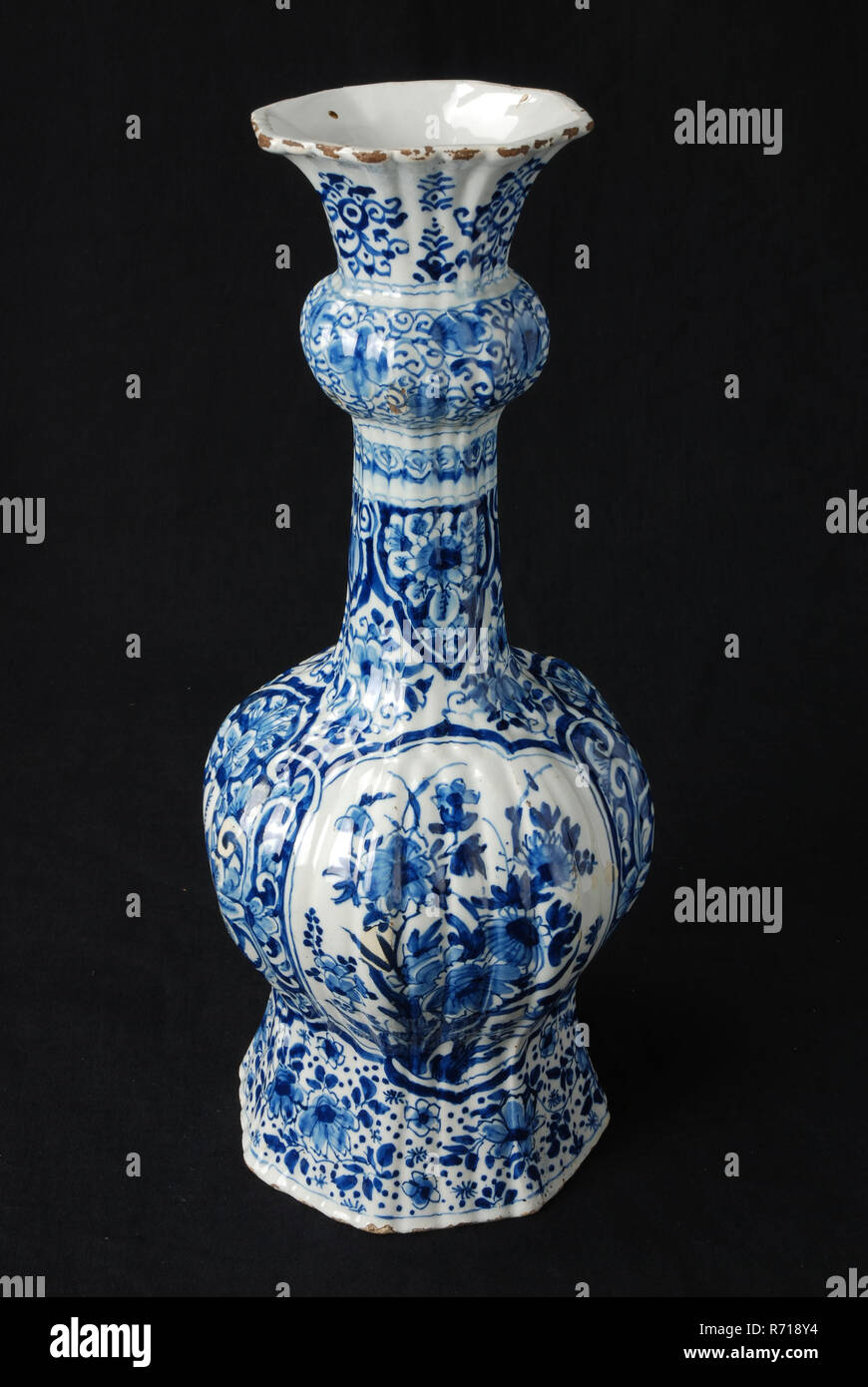 White vase with blue decoration of flowers knob vase vase white vase with blue decoration of flowers knob vase vase crockery holder ceramic earthenware glaze baked painted glazed part of cabinet set baluster shaped body long narrow neck with protuberance above the center wide chalice mouth rotterdam delfshaven middelland heemraadssingel cabinet set delft blue chinoiserie decorate home interior house at heemraadssingel rotterdam R718Y4