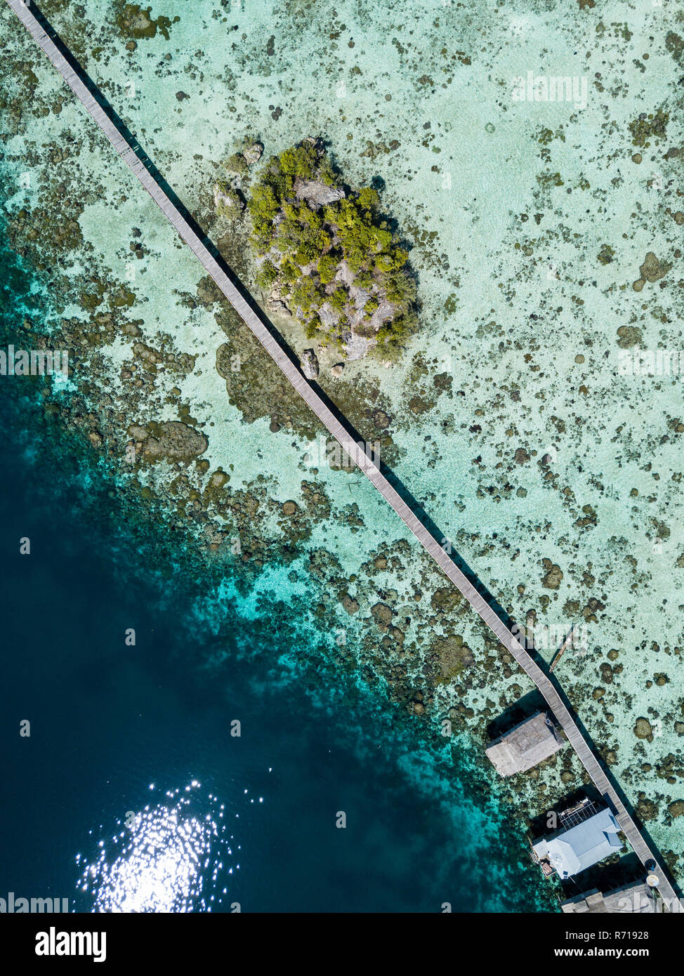 A top aerial view of the connecting bridge to the main island from the sea gypsy village in the Togian Islands in Sulawesi, Indonesia Stock Photo
