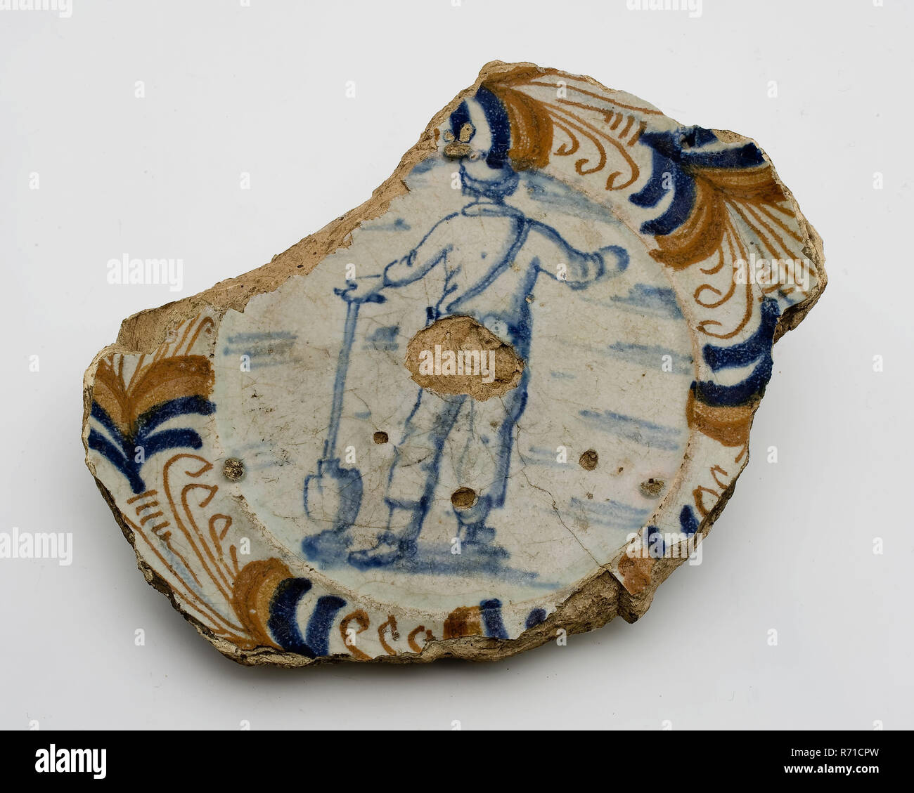 Fragment dish, polychrome, man leaning on shovel, egret edge, dated, dish plate crockery holder soil find ceramic earthenware glaze, majolica Cooked on prunes. Polychrome underside covered with tin glaze on which simple decor in Chinese style and in the stand ring year. Dated Lightly curved soul date backside: 1624 1627 or 1628 archeology Rotterdam Stadscentrum Stadsdriehoek Haringvliet New harbor decorate serving food plateelbakkerij China Soil discovery New Haven Haringvliet 1941. Stock Photo