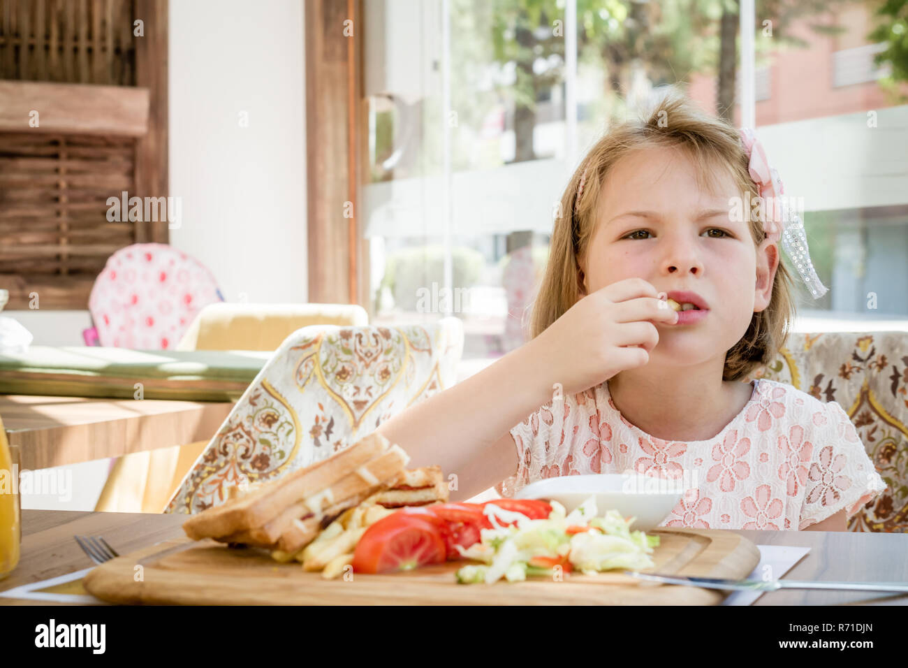 Little Cute Girl Eating Toast with Salad at Breakfast Stock Photo - Alamy