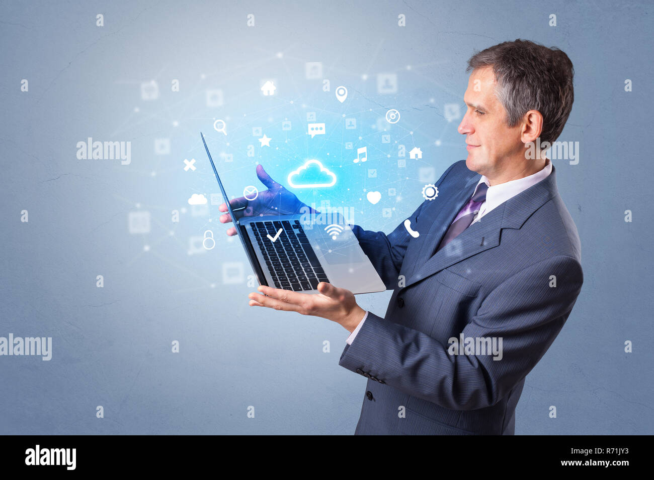 Man holding laptop projecting notifications, symbols and information based on cloud technology system  Stock Photo