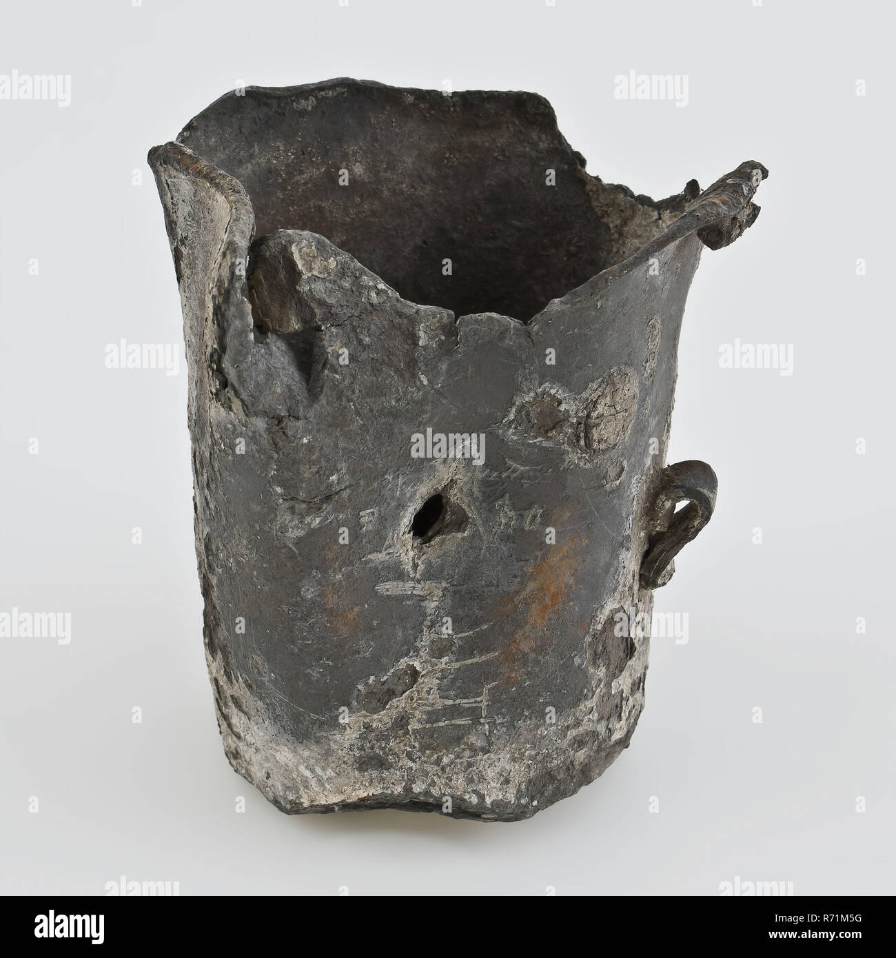 Metal cup with ear, protruding upper edge, lead or tin, cup holder soil find lead tin metal, cast soldered Tin or lead cup Almost cylindrical side wall and protruding upper edge Narrow upright ear. Stand surface. Heavily damaged by staying in the soil archeology native product drinking serving serve measuring Stock Photo