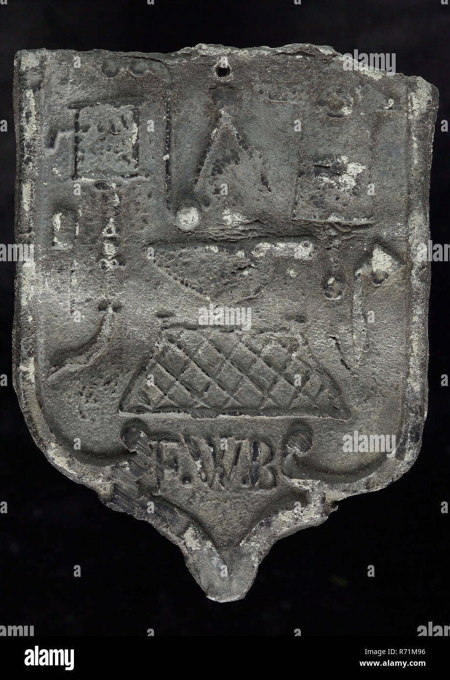 FWB, Roof blank, shield-shaped cover plate with initials FWB and guide tool, plummet lead metal, Roof lead shield-shaped cover of the nails with embossed various guide tools and the initials of the plumber F.W.. on picture: F.W.. leader Stock Photo