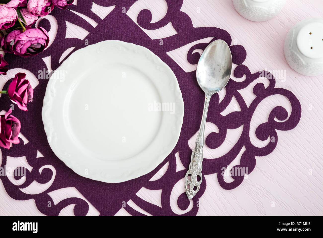 Dinner Table Arranged with Artificial Flowers and Colorful Runners Stock Photo
