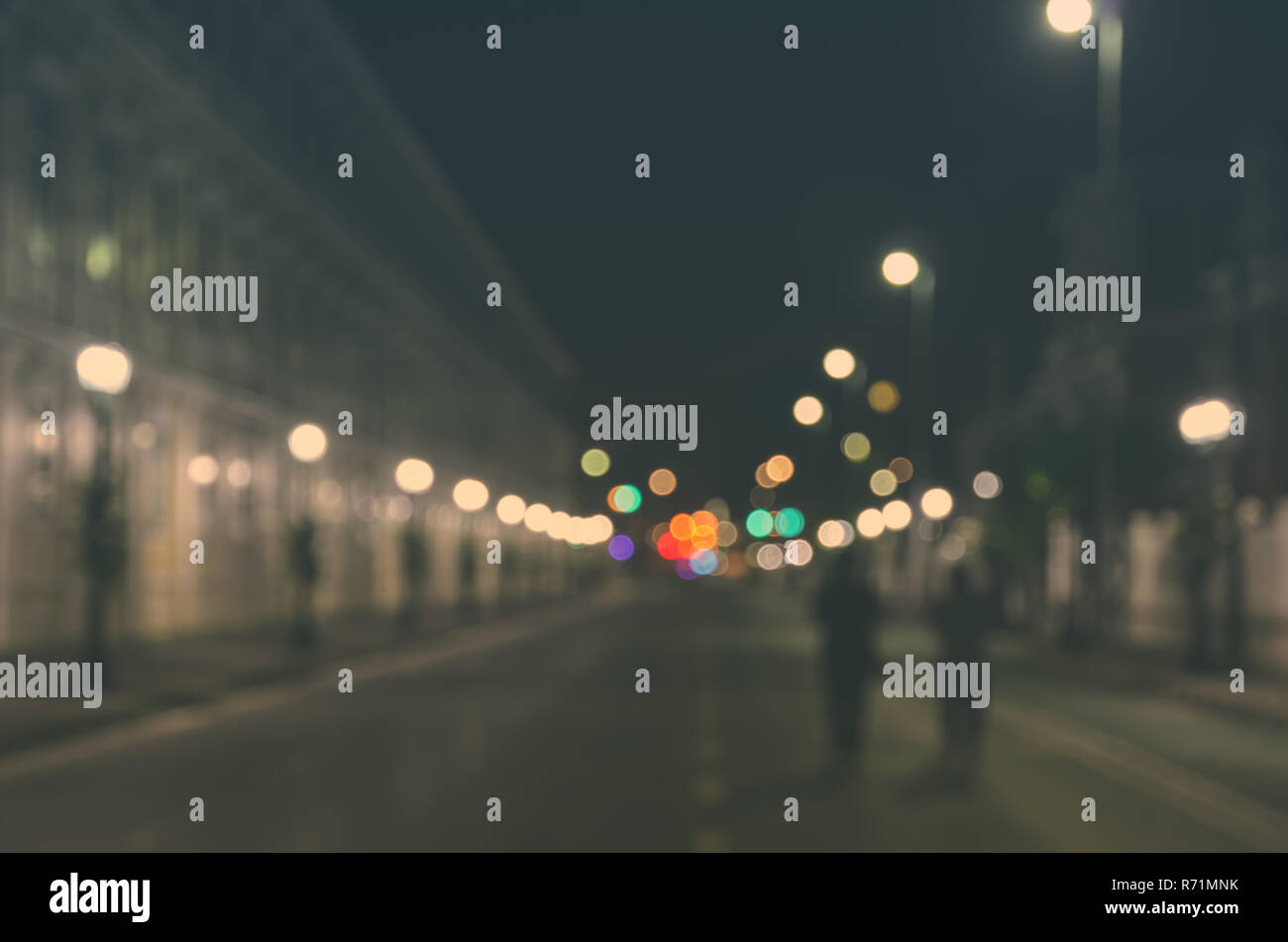Blurred image of people walking through a city street with empty car at ...