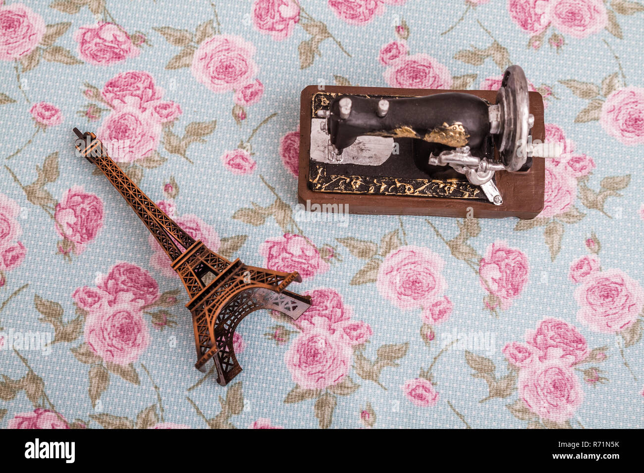 Statue Model of Eiffel Tower and Sewing Machine on Floral Background Stock Photo