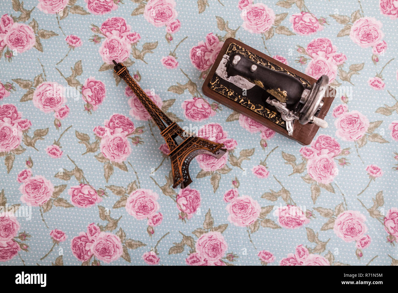 Statue Model of Eiffel Tower and Sewing Machine on Floral Background Stock Photo