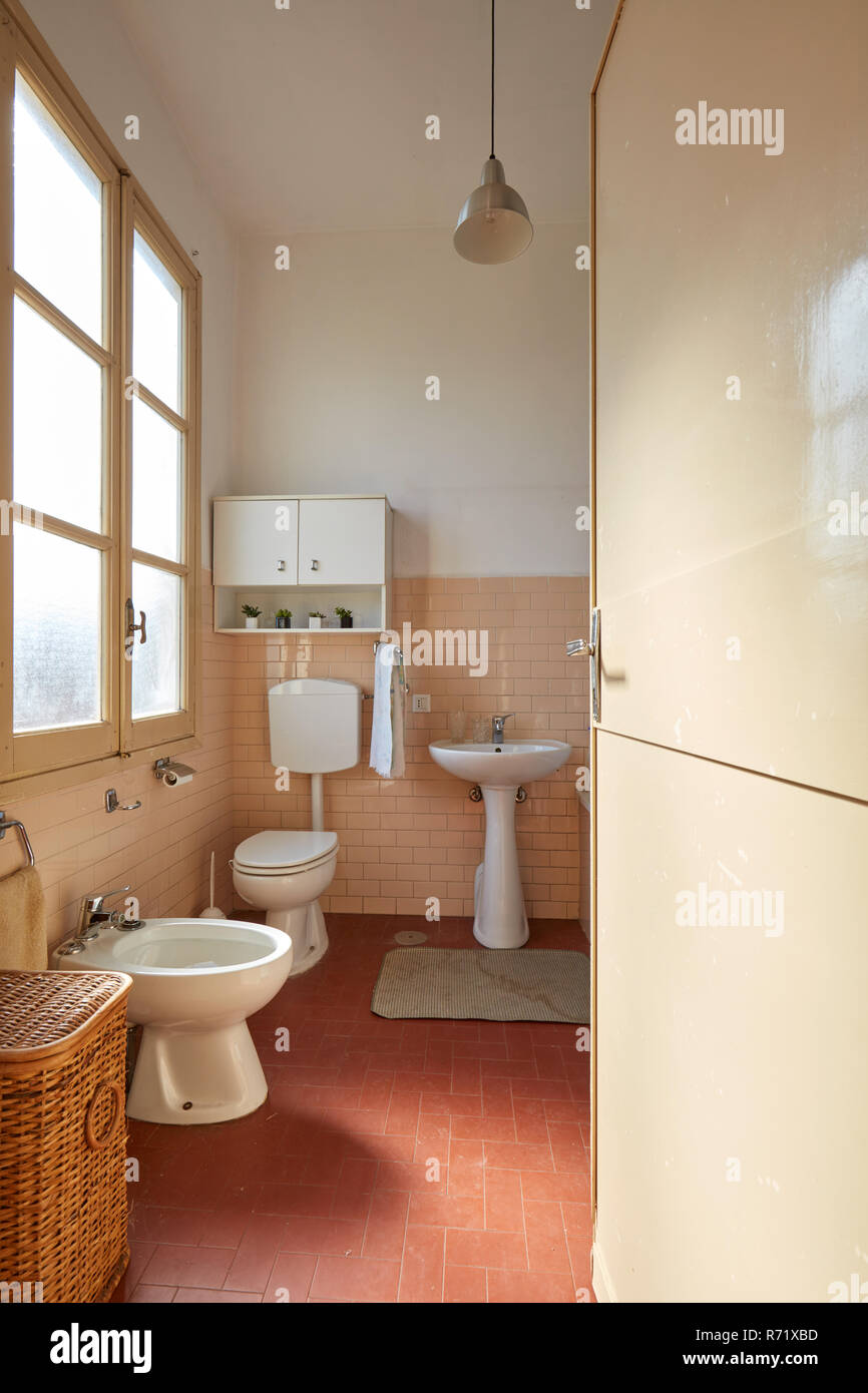 Normal bathroom with pink tiles in old apartment interior Stock Photo
