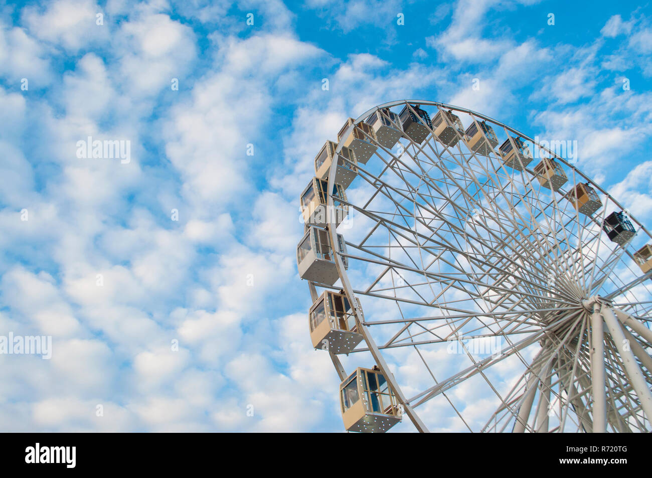 Ferris wheel over blue cloudy sky in a fun park Stock Photo - Alamy