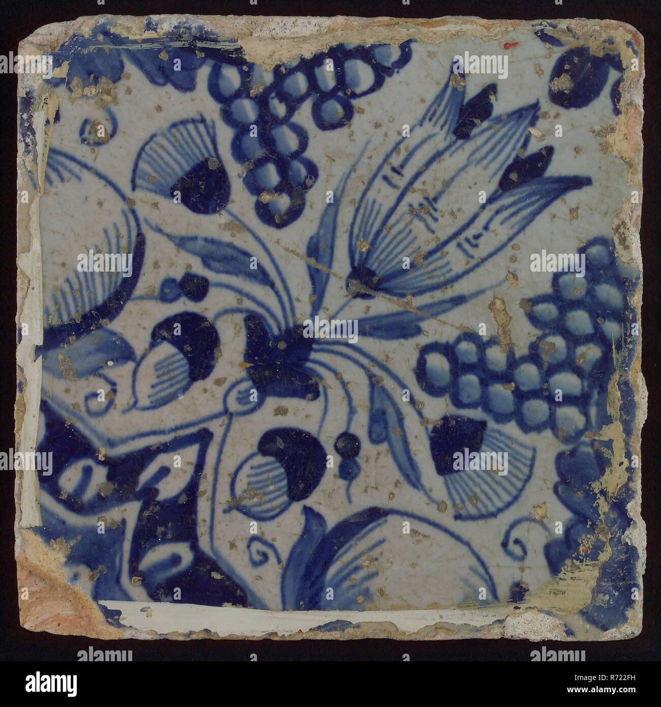 Ornament tile, star tulip with half bunch of grapes and half orange apple, corner pattern quartz and quarter rosette, wall tile tile sculpture ceramics pottery glaze, baked 2x glazed painted Ragged shard square Four nail holes. Two-tone: blue on white Bellevue Rotterdam Hillegersberg-Schiebroek Hillegersberg Zuid Kleiweg Originating from former Huize Bellevue Kleiweg 427 Rotterdam. Stock Photo