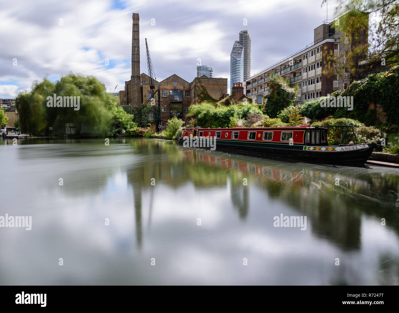 London, England, UK - September 21, 2018: Trees are blown in the wind at City Road Lock on the Regent's Canal, beside a traditional narrowboat and ind Stock Photo