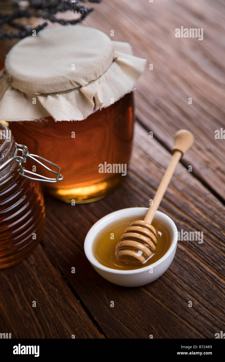Honey jar with dipper and flowing honey Stock Photo Alamy