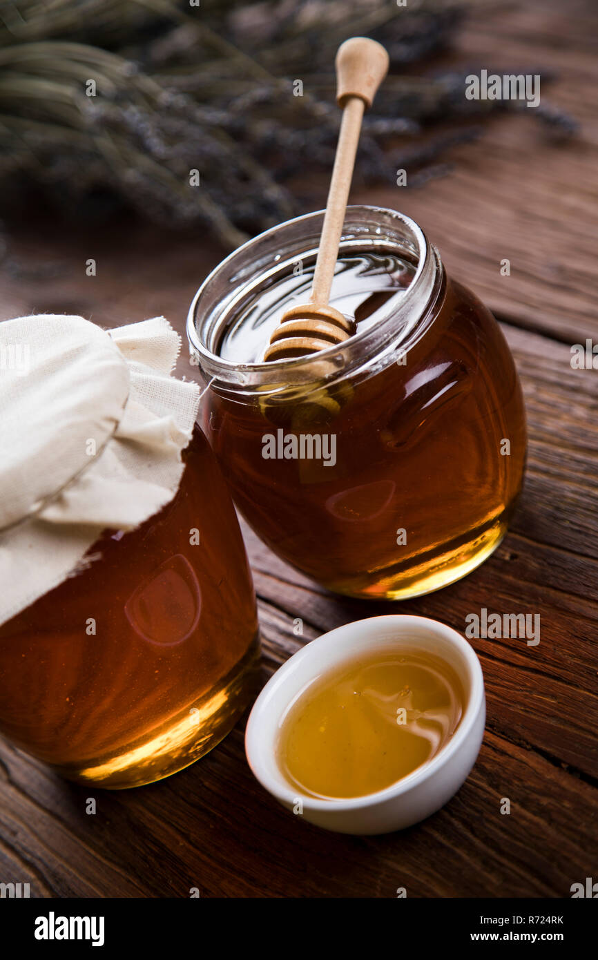 Honey jar with dipper and flowing honey Stock Photo Alamy