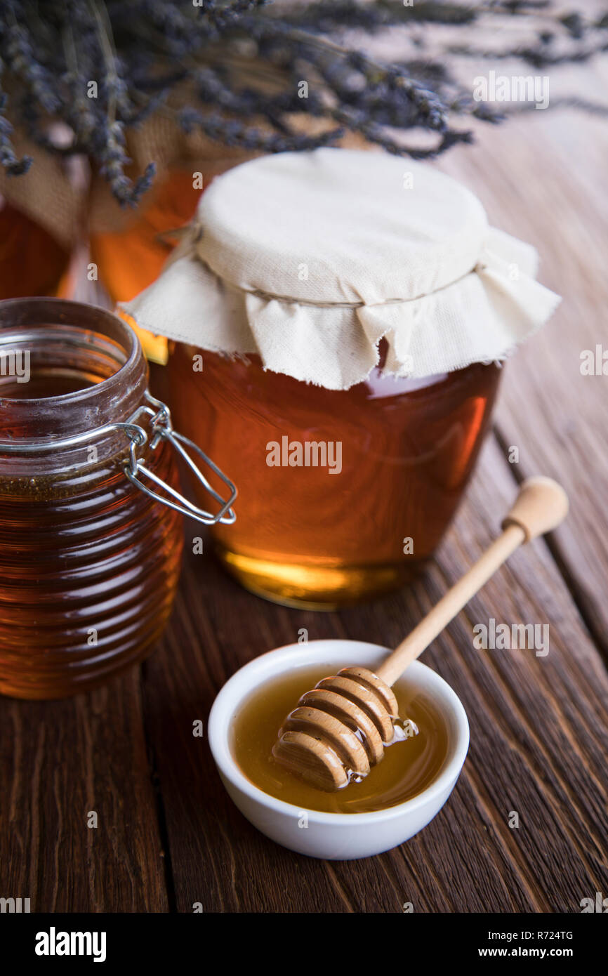 Honey jar with dipper and flowing honey Stock Photo Alamy