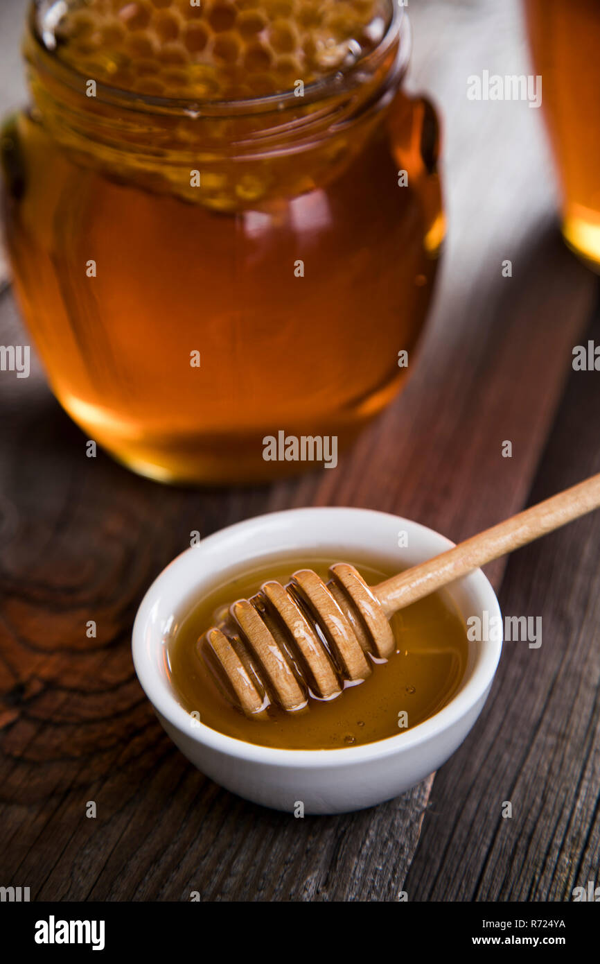 Honey jar with dipper and flowing honey Stock Photo Alamy