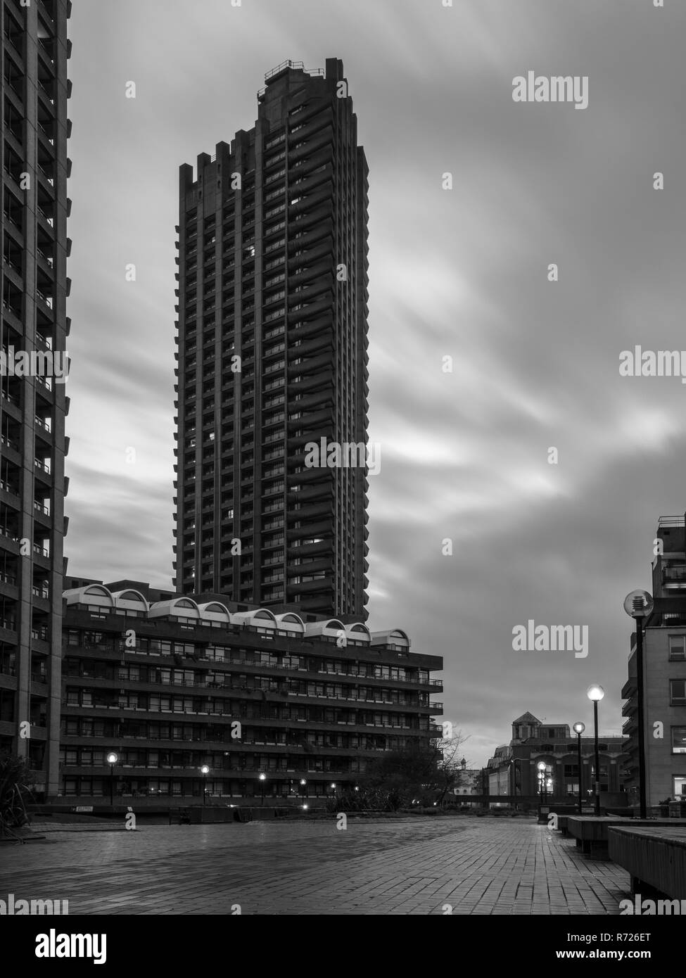 London, England, UK - April 4, 2018: Clouds are blown over the brutalist concrete high rise apartment blocks of the Barbican Estate in London. Stock Photo