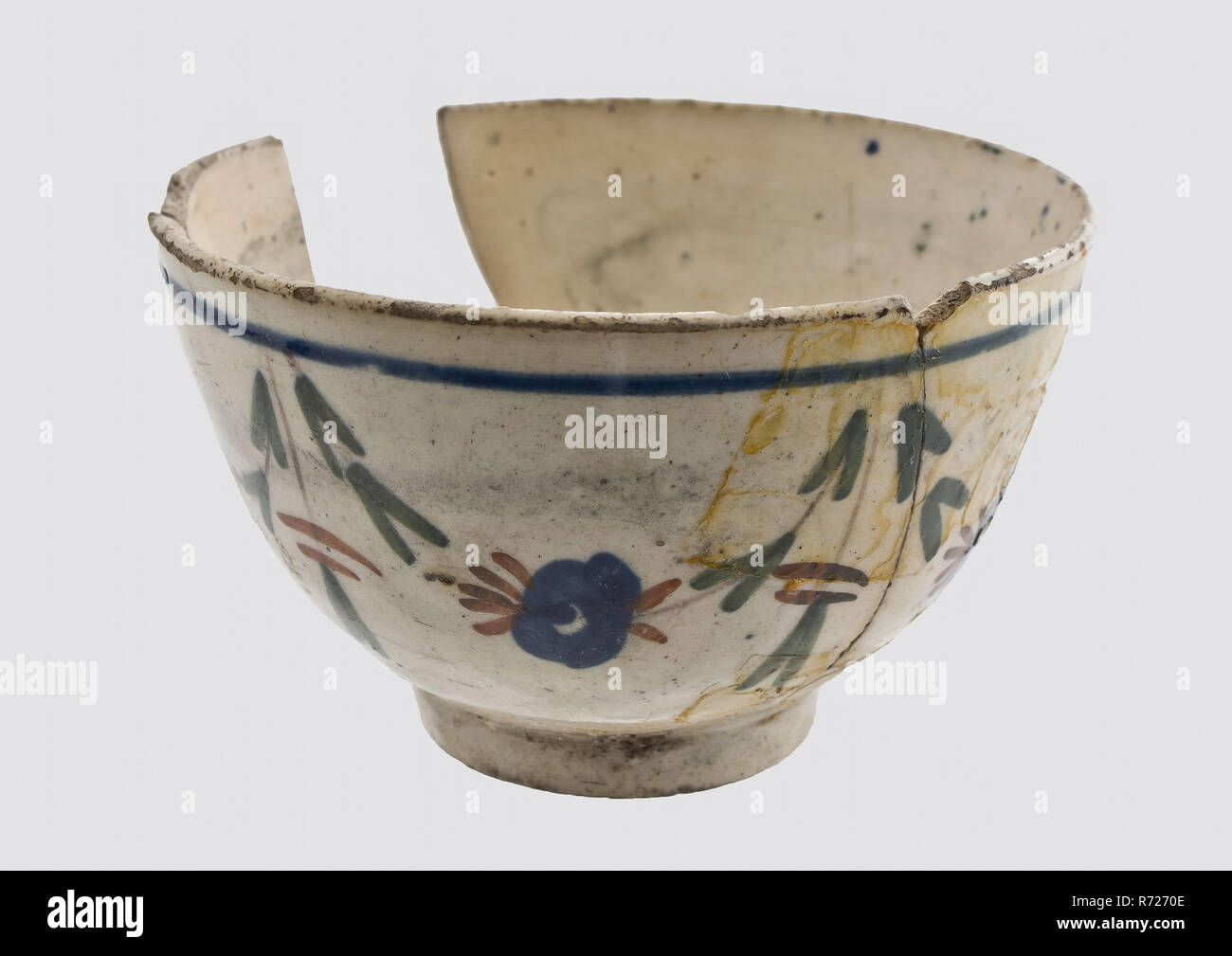 Tea bowl with simple colored flower garlands on the outside wall, bowl crockery holder soil find ceramic porcelain glaze, in form made hand-painted glazed fried Small bowl on stand. White earthenware or industrial white Decoration applied by hand Polychrome consisting of flower garlands in the colors green red manganese and blue Highly discolored by staying in the soil archeology Valckensteyn Poortugaal Albrandswaard indigenous pottery drinking tea drinking tea serving Soil discovery Poortugaal Castle Valckensteyn. Stock Photo