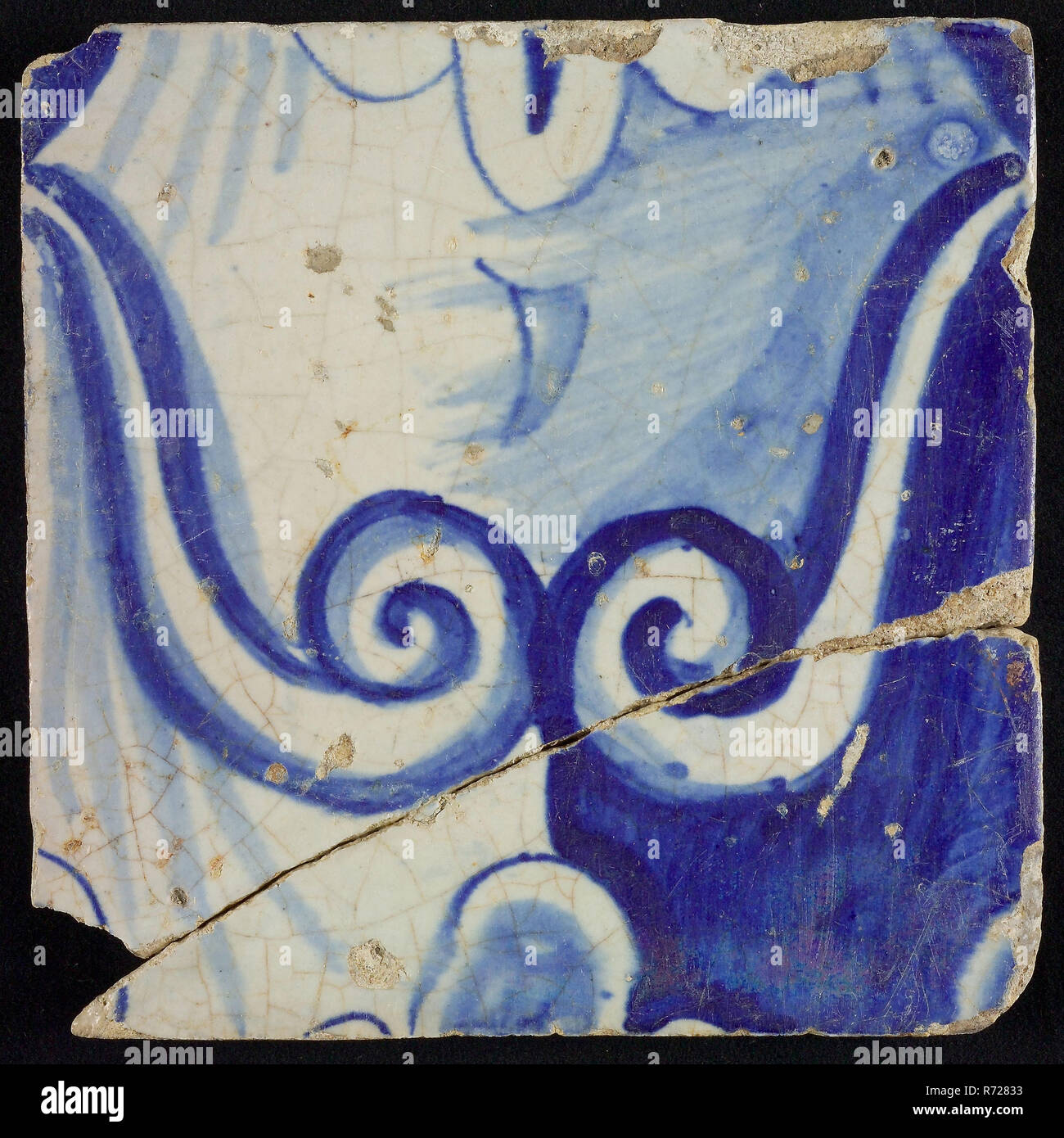 Tile of chimney pilaster, blue on white, part of column with curly ornament and stylized belly button, chimney pilaster tile pilaster footage fragment ceramics pottery glaze, baked 2x glazed painted Three tiles of which two adjoining one-row chimney pilaster originally twelve high upper left C or G with left behind from the middle 9 1914 building town hall Zandstraat-Quarter Second World War war bombardment Rotterdam City Triangle 1940 Renaissance Coming from debris after bombing on Rotterdam in May 1940. Stock Photo