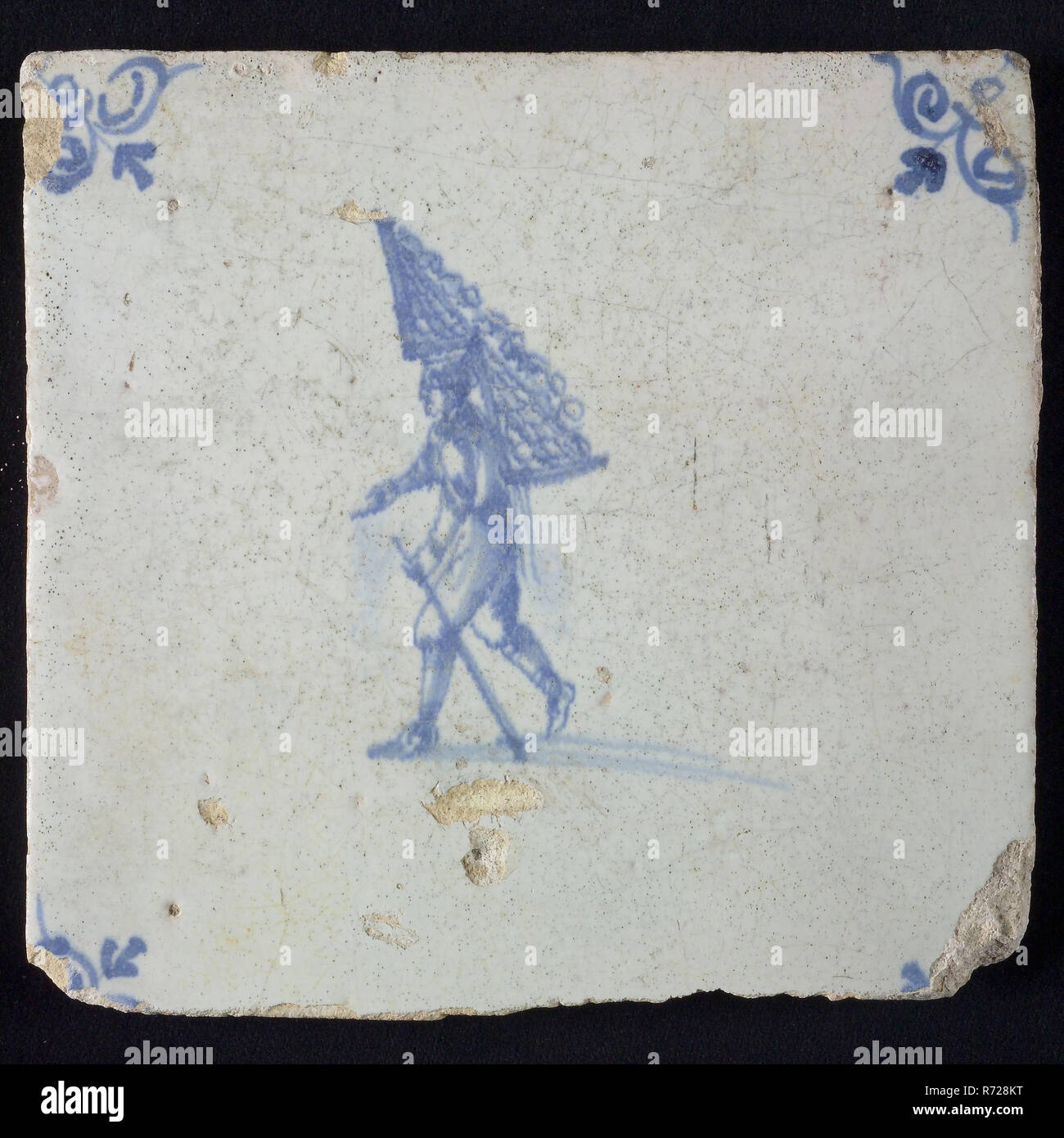 Occupation tile, blue with man with rack of firewood On the back, corner motif oxen head, wall tile tile sculpture ceramic earthenware glaze, baked 2x glazed painted Stock Photo