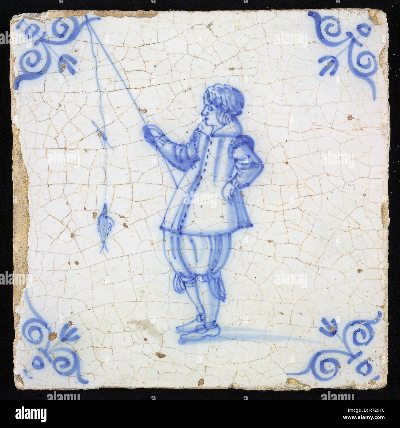 Figure tile, blue with man with fishing rod with fish, corner motif of ...