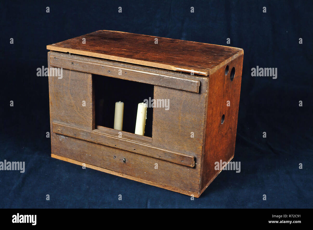 Lightbox, illumination box with panel with conductors and five candles, light box illumination box wood metal, Rectangular wooden box lined inside with tin Both short sides have three holes: two small and one large. One of the long sides has panel that is both reversible and removable. There is rectangular opening in this panel; on both sides (inside and outside) are above and below conductors In the guides different formats of plates with images can be inserted. Removing the panel gives the opening the size of the accompanying slide panoramas. In the cabinet there is separate tin holder with  Stock Photo