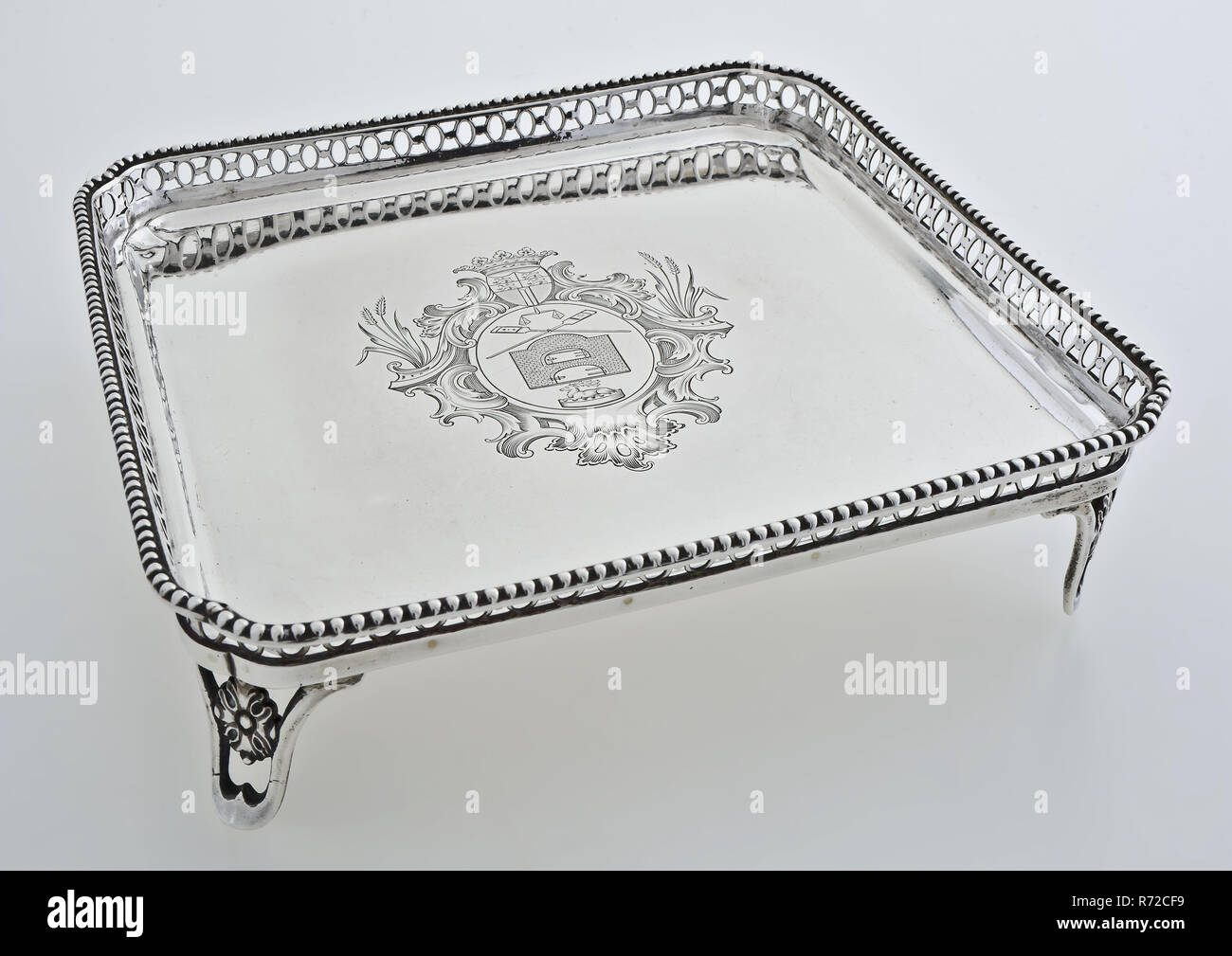 Rudolph Sondag, Silver leaf, with engraving of the Rotterdam bread, pies and cuckoo's guild, tray tray holder silver, Cabaret, ie serving tray on legs. Square chamfered cut out edge on the corners (chain with circles) crowned with pearl surround. Rosette in the open sawn legs. In the middle of the flat engraved with representation of the 'coat of arms of pie and bakers': oval decorated with ears of corn crowned with weapon Rotterdam underneath balance two crossed bread scoops double door oven and pie crowned with deer head inscription backside: wood pastey & koekebakkers Guild 1790 (engraved i Stock Photo