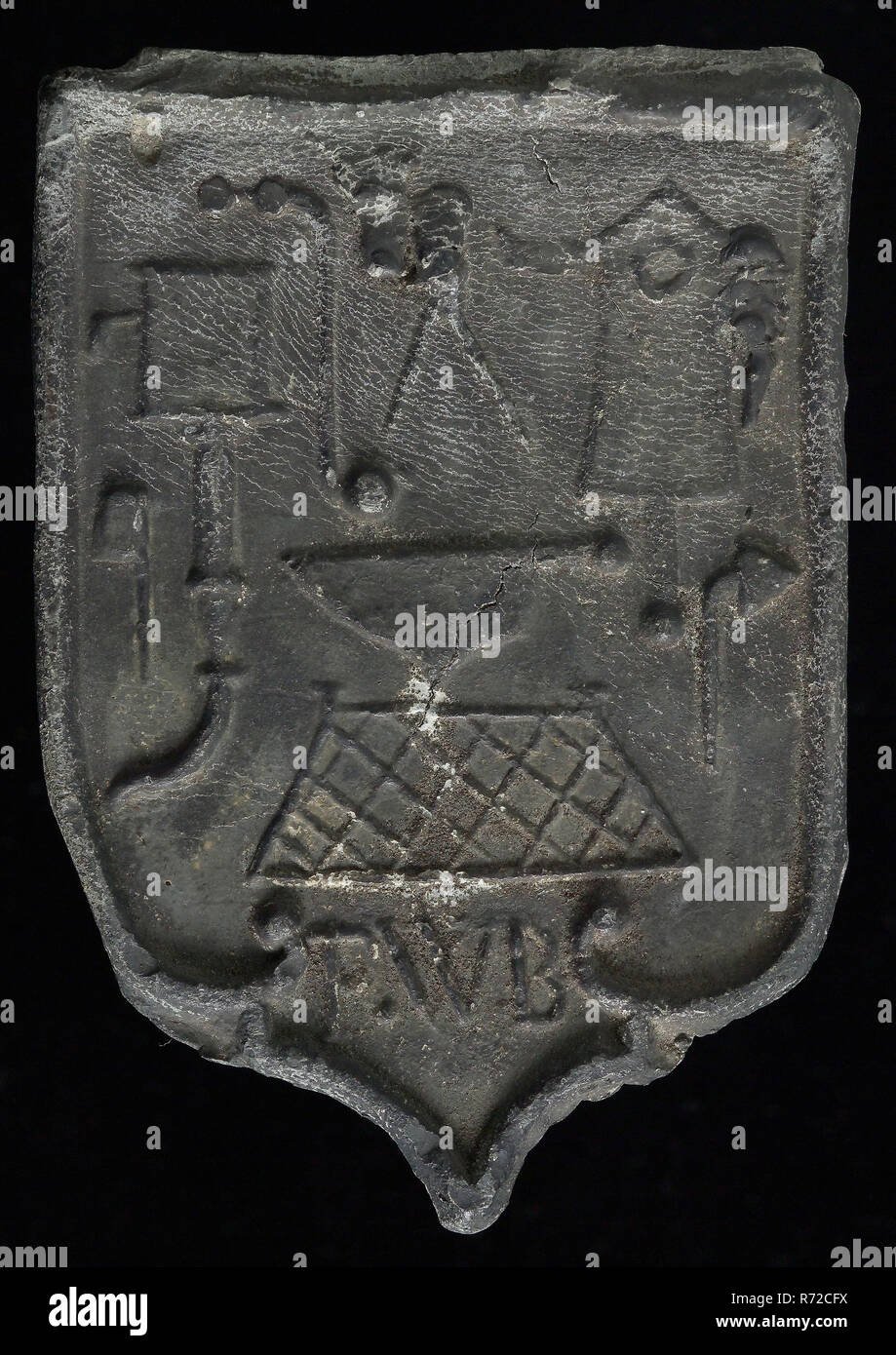 FWB, Roof lead, shield-shaped cover plate with initials FWB and various guide tools, bracing lead quality mark metal lead, Roof bonnet shield shaped cover of the nails with the initials of the plumber F.W.. and above various guide tools, F.W.. slate From the roof of the Courthouse on the Kloosterlaan in Breda. Stock Photo
