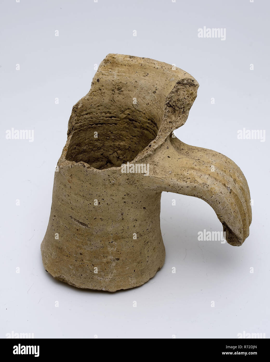 Neck fragment of jug with part of rim and ear, amphora jar holder soil find ceramic pottery, hand-turned baked neck fragment. Roman jug. Yellow-gray pottery. Blasted with gritty material. Profiled ear with three grooves. Neck with cuff collar archeology indigenous pottery import transport store save save Roman Stock Photo