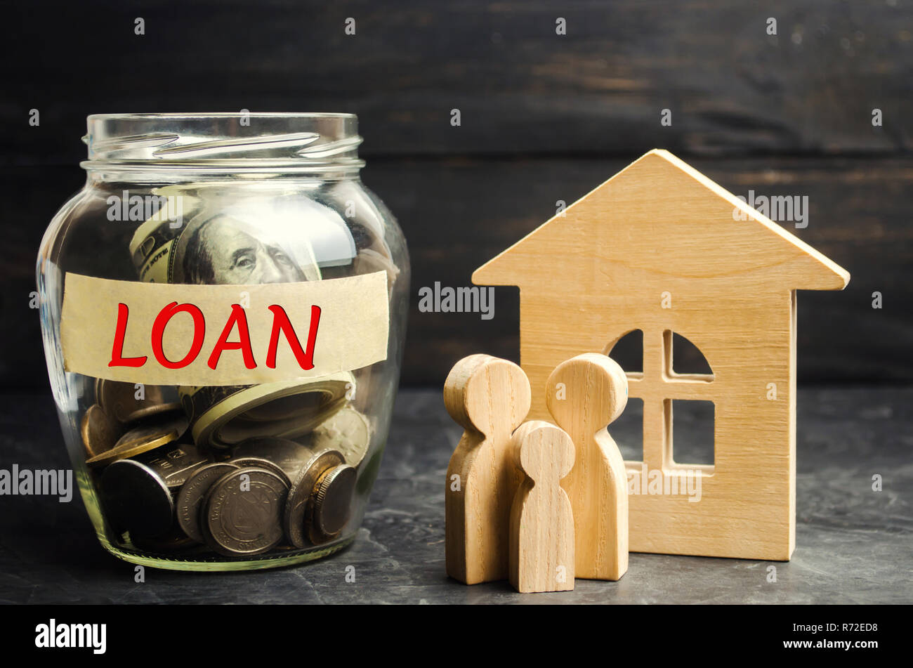 Model of the house, money and the inscription 'Loan'. Buying a home in debt. Family investment in real estate and risk management concept. Loan for a  Stock Photo