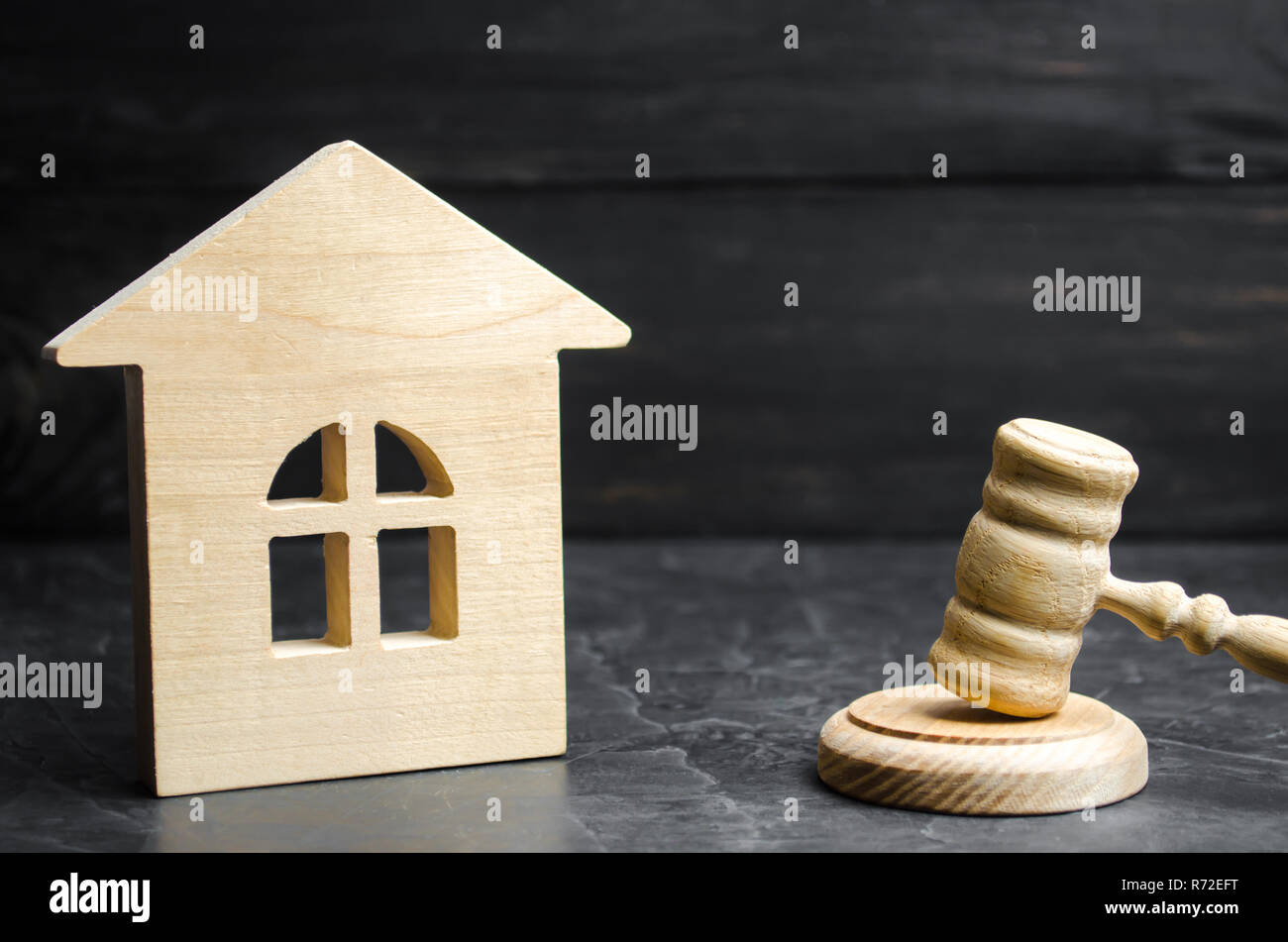 A miniature wooden house and a hammer of the judge. Auction to buy / sell a house. Forced eviction and confiscation. Clarification of ownership of pro Stock Photo