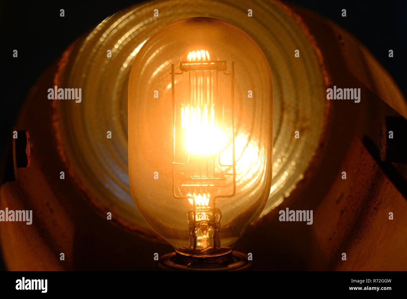 close up tungsten stage lightbulb filament glowing when switched on Stock Photo