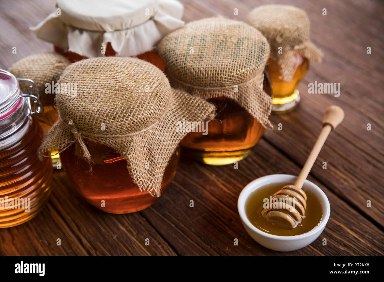 Honey jar with dipper and flowing honey Stock Photo Alamy
