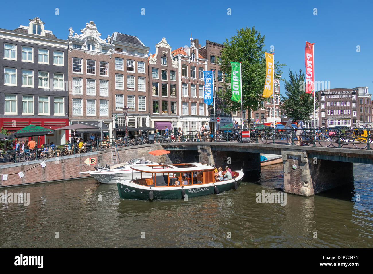 Tourists making sightseeing trip by launch ship in Amsterdam canals Stock Photo
